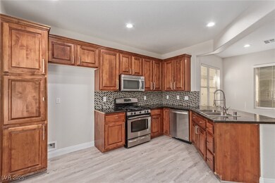 Kitchen featuring a peninsula, brown cabinetry, ap