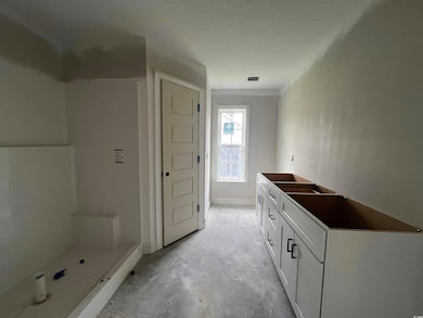 Bathroom with a shower stall, unfinished concrete flooring, and vanity
