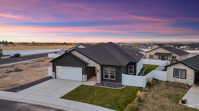 View of front of property featuring stone siding, board and batten siding, driveway, a shingled roof, and an attached garage