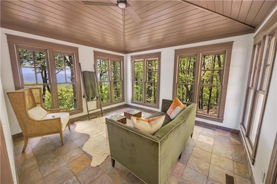 Sunroom / solarium featuring stone tile floors, wo