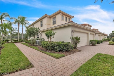 View of property exterior featuring a yard, stucco siding, and decorative driveway