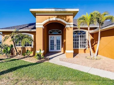 Property entrance with french doors and a lawn