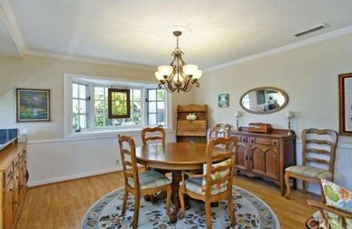 Dining room has crown moldings, chair rails & wain