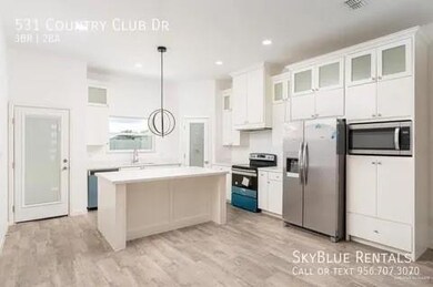 Kitchen with white cabinetry, a center island, light hardwood / wood-style floors, hanging light fixtures, and appliances with stainless steel finishes
