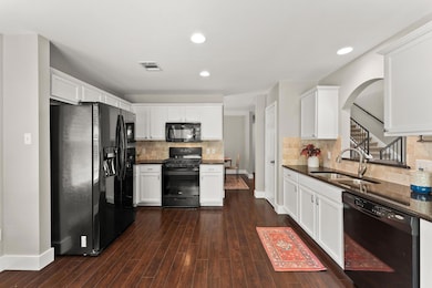 Kitchen featuring black appliances, dark countert