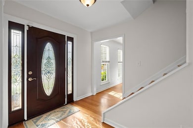 Foyer with baseboards, wood finished floors, a hea