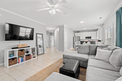 Tiled living room with ceiling fan and ornamental 