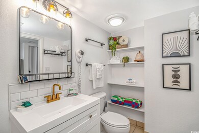 Bathroom with vanity, toilet, and backsplash