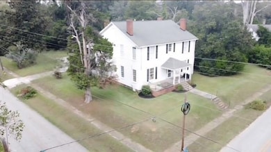View of subject property with a tree filled landscape
