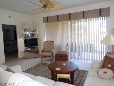 Carpeted living room featuring ceiling fan