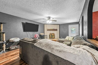 Living area with a fireplace, a textured wall, cei