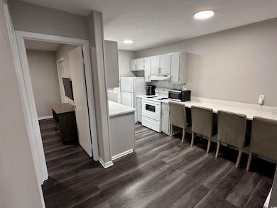 Kitchen with light countertops, white appliances, 