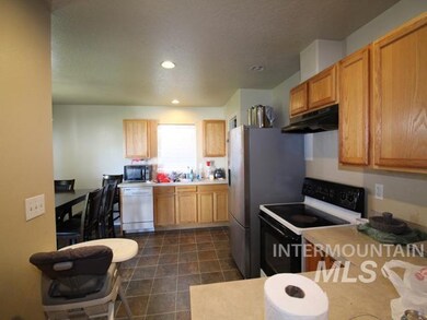 Kitchen featuring electric range oven, under cabinet range hood, light countertops, white dishwasher, and recessed lighting