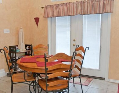 The informal dining area is on ceramic tile and cl
