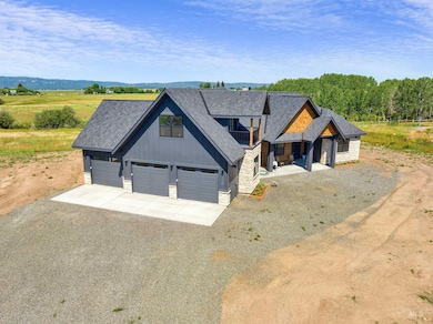 View of front of property featuring stone siding, driveway, and roof with shingles