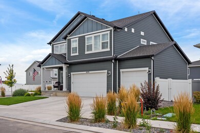 Craftsman inspired home with board and batten siding, driveway, roof with shingles, and an attached garage