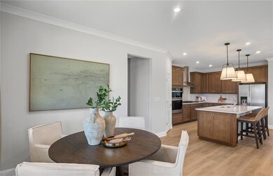 Dining room with baseboards, light wood finished floors, ornamental molding, and recessed lighting