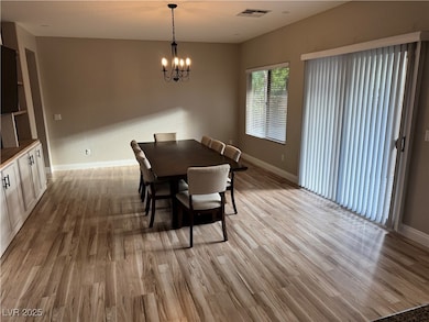 Dining space with light wood finished floors and a chandelier