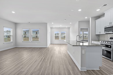 Kitchen with dark stone counters, sink, an island 