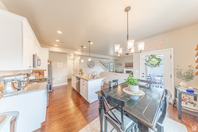 Dining room with stairway, light wood-style floors, recessed lighting, and a chandelier