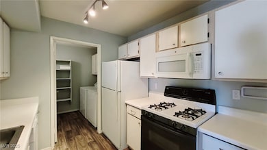 Kitchen with white appliances, washer and clothes