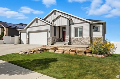 Craftsman house featuring stone siding, driveway, board and batten siding, and a garage