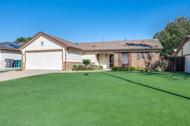 Ranch-style house featuring brick siding, driveway, a garage, and a shingled roof