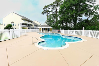 Community pool with a patio area and an outdoor structure