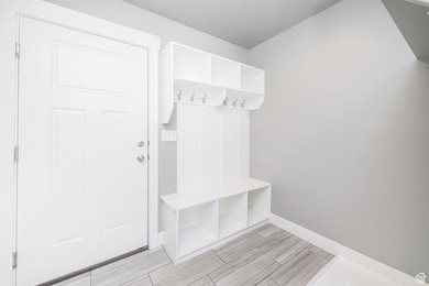 Mudroom featuring baseboards and wood tiled floors