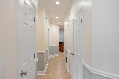 Hall with light tile patterned floors, recessed lighting, and ornamental molding