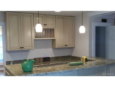 Kitchen Island and rear work space features large pot drawers and open plate storage.  To the right is the door to a spacious walk in pantry.  To the left is the opening to the dining room.  Recessed and pendant lighting gives it an upscale air.