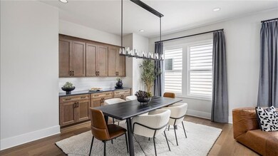 Dining room with built-in cabinets, light wood-type flooring, and recessed lighting. Photos are of the Tallulah Model Home and are not representative of actual home. Designer features may vary.