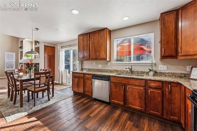 Kitchen featuring a sink, light stone countertops,