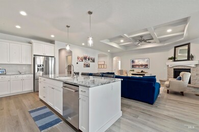 Kitchen with arched walkways, appliances with stainless steel finishes, coffered ceiling, open floor plan, and recessed lighting