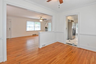 Spare room with light wood-style flooring, ornamental molding, and ceiling fan
