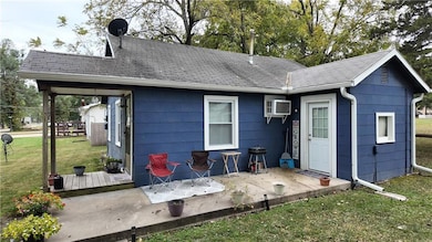 Back of property featuring a yard, a patio, roof with shingles, and a deck
