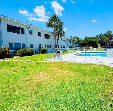 Pool with a lawn, fence, and central air condition