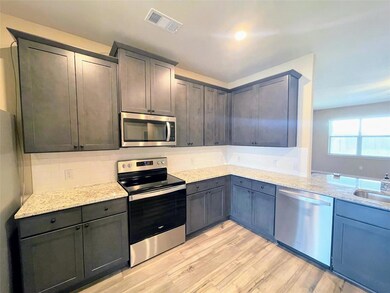 Kitchen featuring visible vents, light stone count
