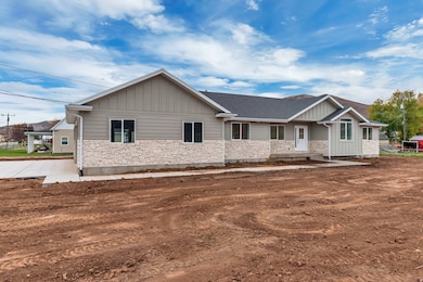Craftsman inspired home featuring stone siding, board and batten siding, and roof with shingles