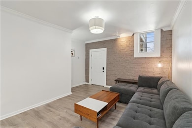 Living room featuring wood-type flooring and crown