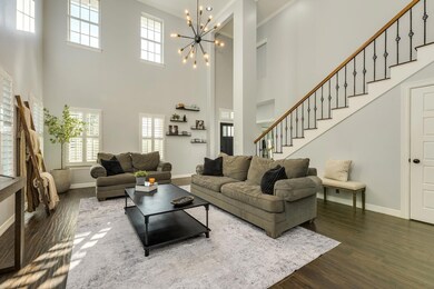Living room featuring stairs, a high ceiling, ple