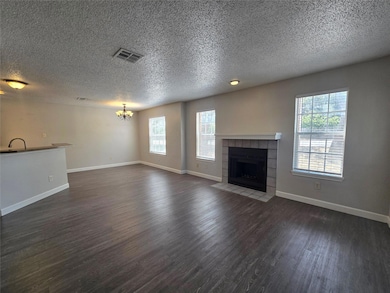 Unfurnished living room with a tile fireplace, he