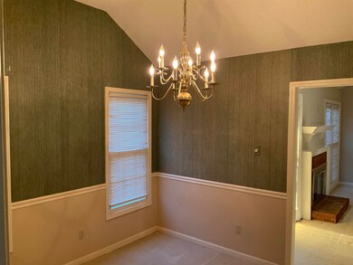 Unfurnished room with lofted ceiling, a brick fire