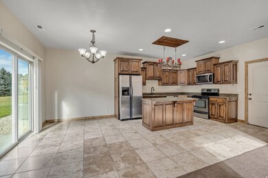 Kitchen featuring a chandelier, hanging light fixtures, stainless steel appliances, a center island, and recessed lighting