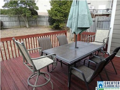 Open deck that overlooks fenced backyard.