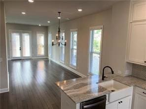 Kitchen with dishwasher, white cabinets, a chandelier, recessed lighting, and open floor plan