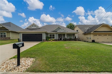 Craftsman house featuring a garage, driveway, a front lawn, and roof with shingles