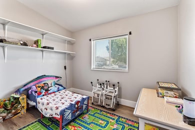 Bedroom featuring wood finished floors and baseboards