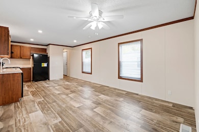 Open-concept living area featuring the decorative ceiling fan and seamless Cafe Au Lait vinyl flooring