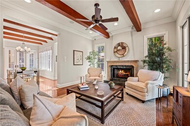Front parlor featuring walnut floors, cypress beamed ceiling, antique fan, French windows, fireplace